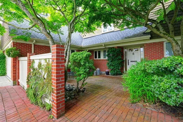 Casa de tijolo exterior com piso de azulejo jardim da frente — Fotografia de Stock