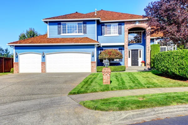 Lichte blauwe huis buitenkant met baksteen trim en pannendak — Stockfoto