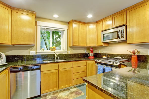 Maple lemari dapur dengan puncak granit hitam — Stok Foto