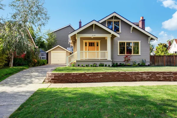 Graues Haus mit weißer Veranda und orangefarbener Tür — Stockfoto