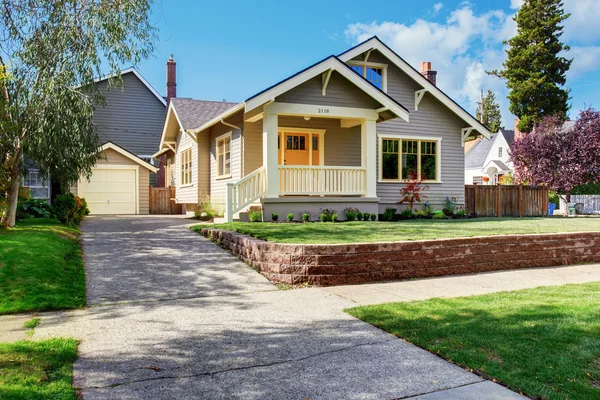 Grey house exterior with white porch and orange door — Stock Photo, Image