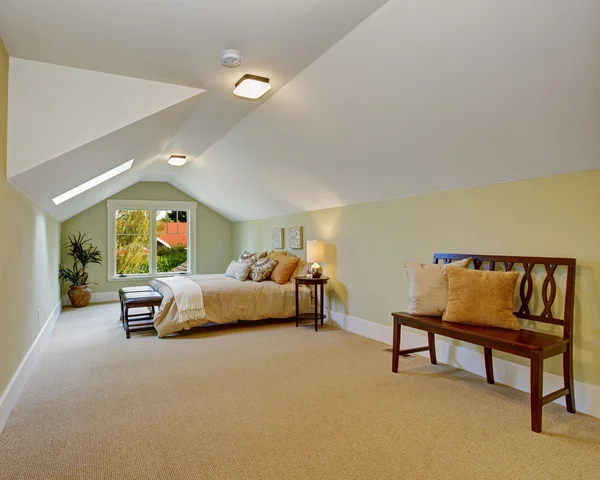 Просторная спальня со сводчатым потолком и светлыми стенами из мяты — стоковое фото