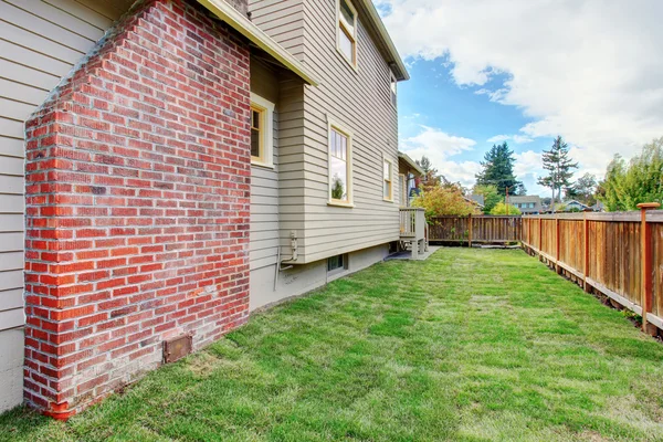 Casa con chimenea de ladrillo y patio trasero cercado — Foto de Stock