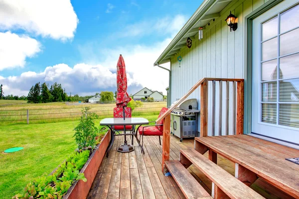 Platteland huis buitenkant met staking dek en kleine patio zijn — Stockfoto