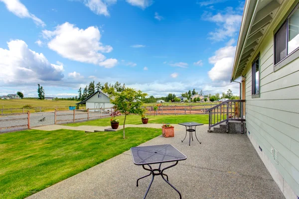 Countryside house exterior with concrete floor walkout patio — Stock Photo, Image