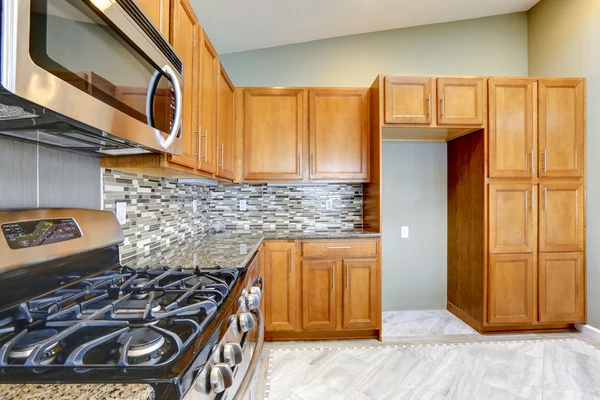 Luxury kitchen room with bright brown cabinets and mosaic wall t — Stock Photo, Image