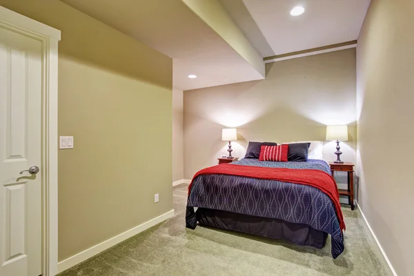 Basement guest bedroom with blue and red bed — Stock Photo, Image