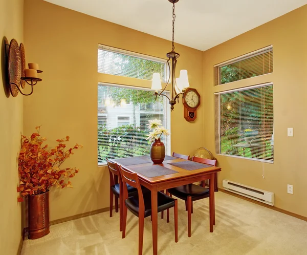 Warm dinning room with carpet and windows.
