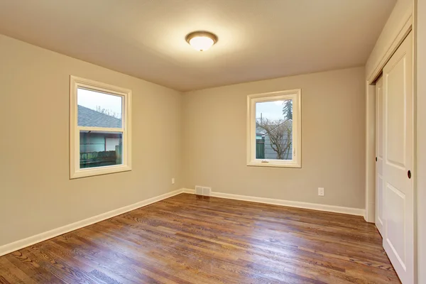 Simple hardwood floor bedroom with windows. — Stockfoto