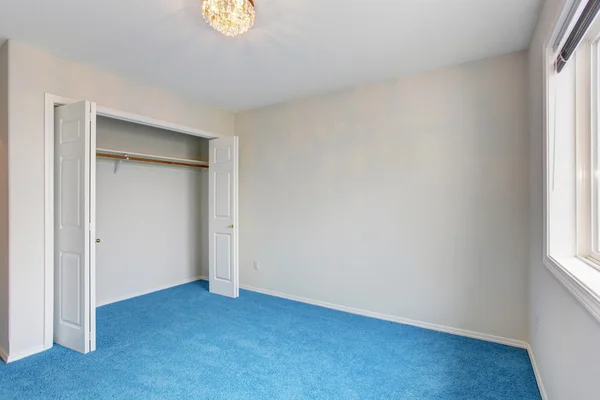 Unmöbliertes Schlafzimmer mit blauem Teppich. — Stockfoto