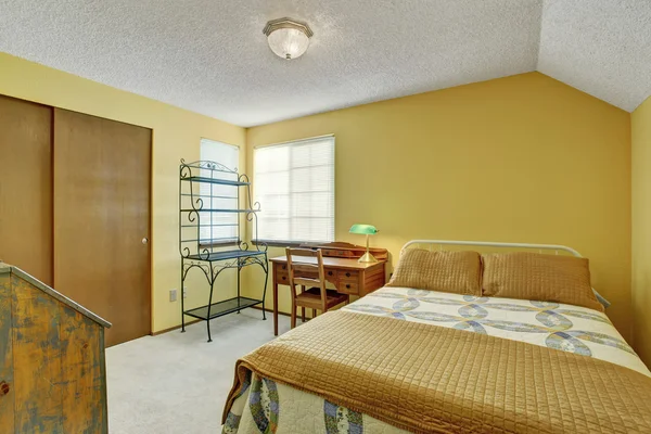 Απλοϊκή υπνοδωμάτιο με τάπητα πάτωμα και το κρεβάτι. — Stok fotoğraf