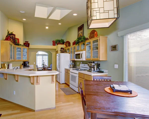 Modernized kitchen with light green walls and hardwood floor. — Stock Photo, Image