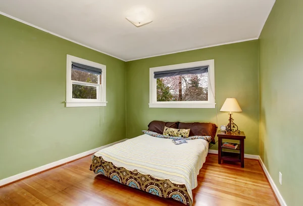 Boho yeşil duvarlar ve ahşap döşeme temalı yatak odası. — Stok fotoğraf