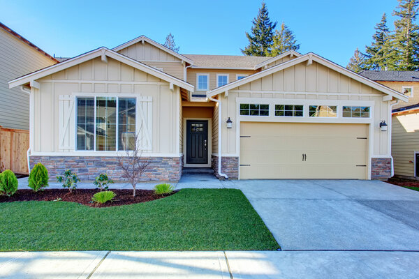 Perfect tan town house with garage and driveway.