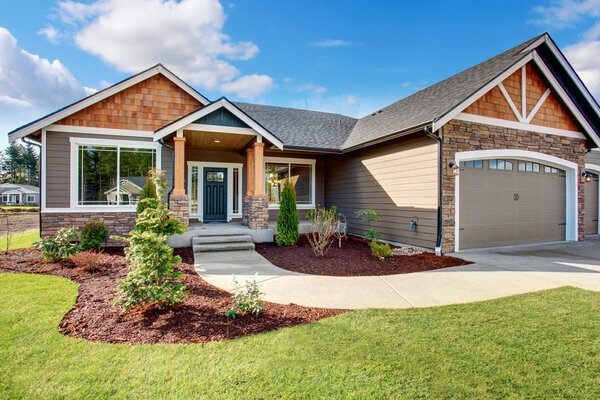 Large modern house with stone and walkway.