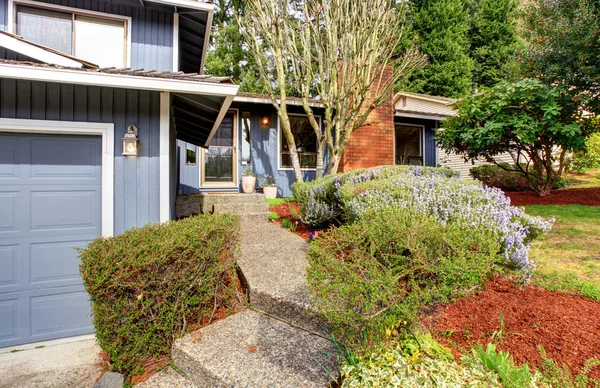 Bella casa blu con ampio cortile contenente erba e terreno . — Foto Stock