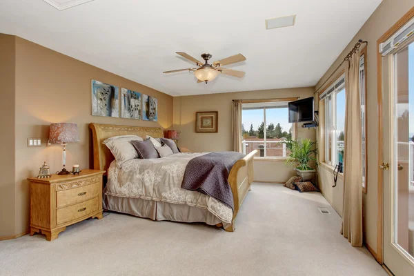Großes Hauptschlafzimmer mit angeschlossenem Badezimmer und cremefarbener Bettwäsche. — Stockfoto
