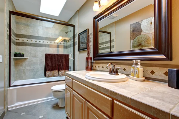 Elegantes Badezimmer mit Glasdusche und großem gerahmten Spiegel. — Stockfoto