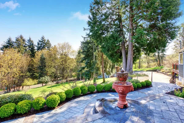 Precioso patio trasero con patio incluyendo elegante fuente y gre — Foto de Stock