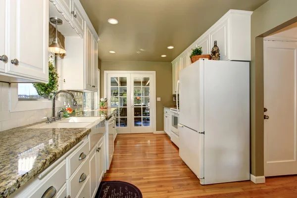 Moderní kuchyně s bílými akcenty a zelené stěny. — Stock fotografie