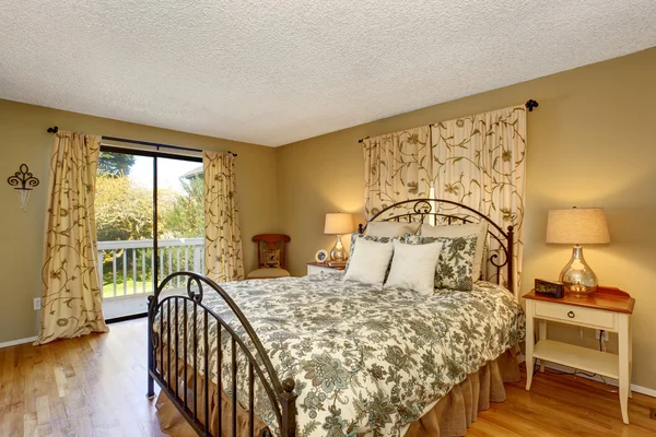 Timeless bedroom with floral bedding and hardwood floor. — Stock Photo, Image