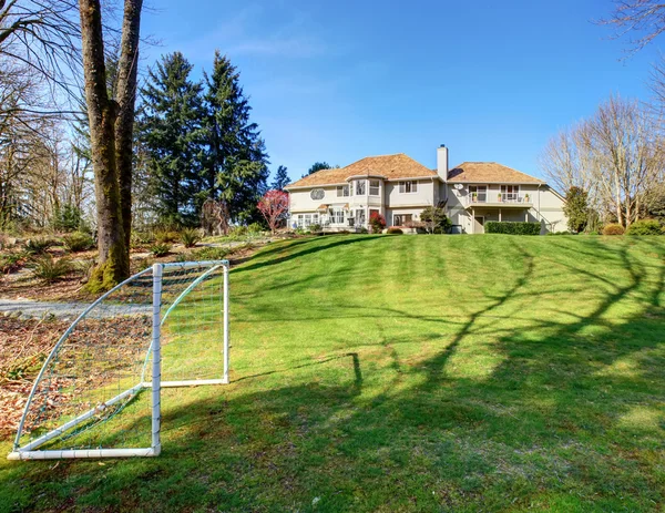 Large back yard with greenery, and furnished back porch. — Stock Photo, Image