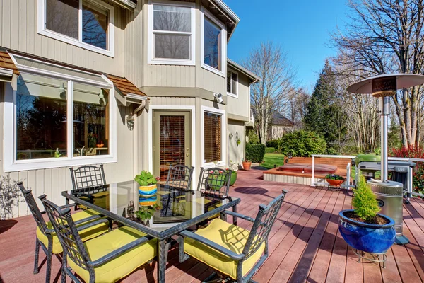 Large back yard with greenery, and furnished back porch. — Stock Photo, Image