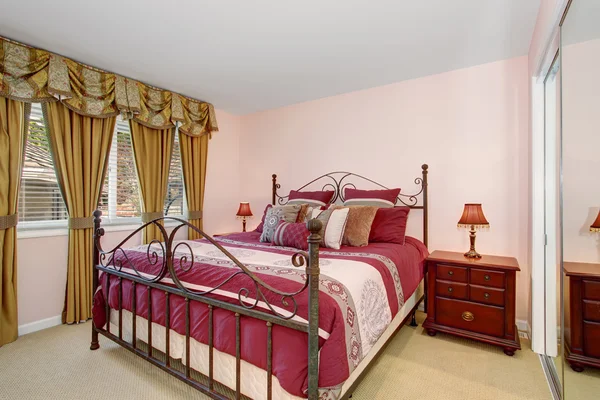 Acogedor dormitorio con ropa de cama roja y alfombra . —  Fotos de Stock