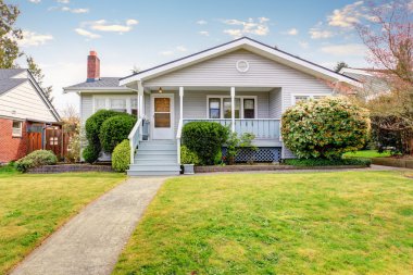 Small American home with light exterior and white trim. clipart