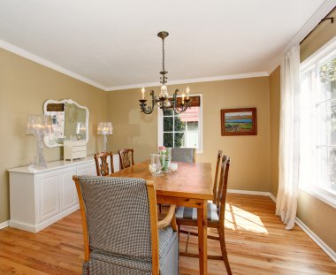 Beyaz dolapları ile klasik yemek odası.