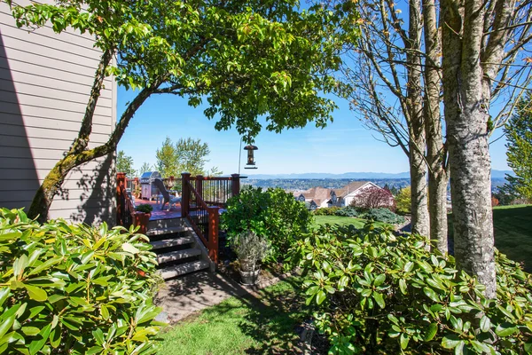 Passerelle vers terrasse meublée avec verdure . — Photo