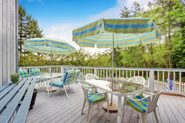 Lovely gray deck with covered table sets. — Stock Photo, Image