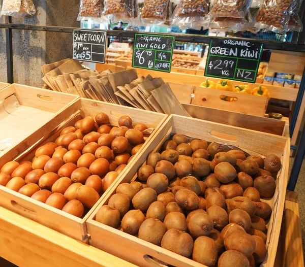 Kisten mit goldenen und grünen Kiwi auf dem Naturkostmarkt in Auckland. — Stockfoto