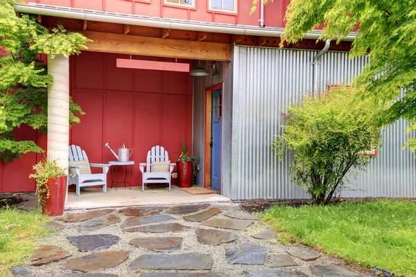 Twee stoelen voor ingang van grote rode huis. — Stockfoto