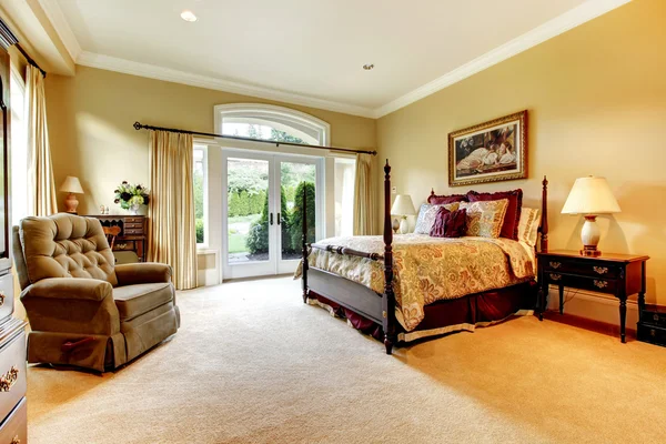 Schönes Schlafzimmer mit eleganter Bettwäsche und einer Glastür. — Stockfoto