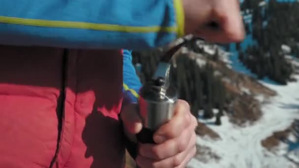 冬の山々を背景に 手動フィールドコーヒーグラインダーでコーヒーを粉砕するクローズアップ 山の中のハイキングで冬にコーヒーを作る — ストック動画