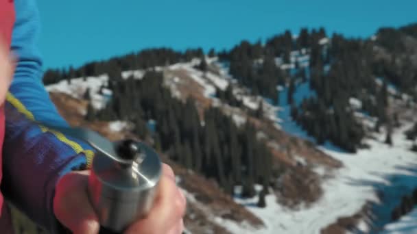 冬の山々を背景に 手動フィールドコーヒーグラインダーでコーヒーを粉砕するクローズアップ 山の中のハイキングで冬にコーヒーを作る — ストック動画