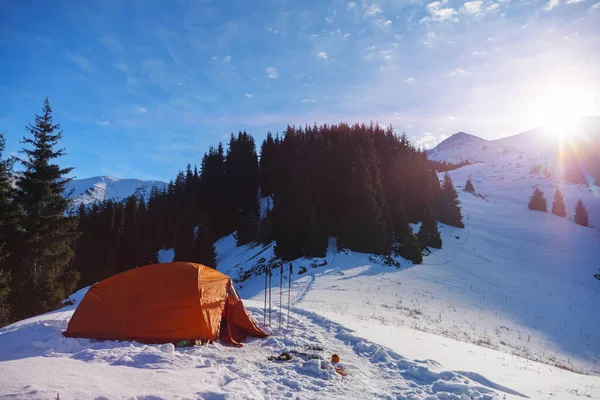 Mountain winter landscape with orange tent. Hiking in the mountains in winter