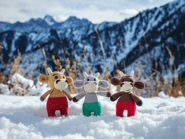 Kışın dağlarda üç komik boğa kar yığınında duruyor. El yapımı Noel ağacı oyuncağı. 2021 'in boğa sembolü