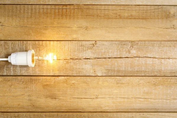 Light bulb on wood — Stock Photo, Image