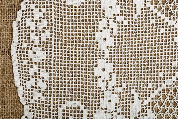 Doily on burlap — Stock Photo, Image