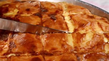 Bıçağa yakın çekim tiropita ya da peynirli turta kesme