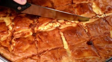 Bıçağa yakın çekim tiropita ya da peynirli turta kesme