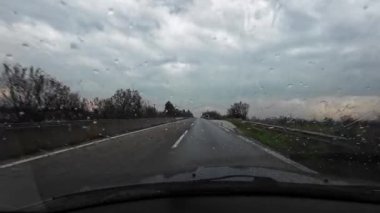 Yağmurlu bir günde iki şeritli asfalt yolda araba kullanmak