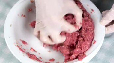 Kadın kasede kıyma hazırlıyor.