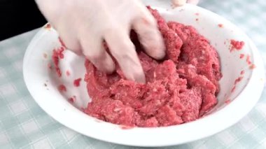 Kadın kasede kıyma hazırlıyor.