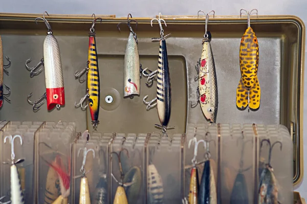 A rare collection of old fishing lures that are hanging on old fisherman\'s tackle box