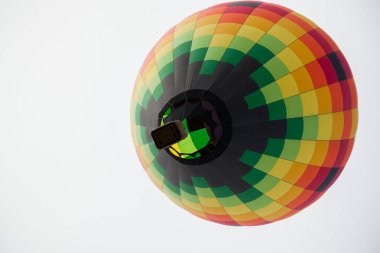 New Mexico 'daki Balon Fiesta' da bulutlu beyaz bir gökyüzünde yukarı doğru süzülen renkli sıcak hava balonunun altındaki manzara..