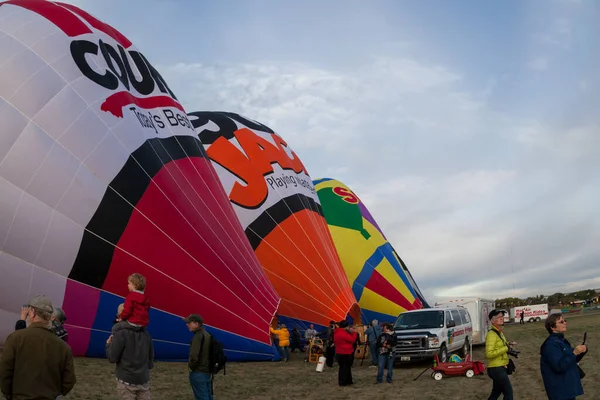 ニューメキシコ州アルバカーキ 2014年10月8日 人々はアルバカーキのバルーンフィエスタで離陸のために熱気球が膨らんでいるので 大規模なフィールドを歩き回る — ストック写真