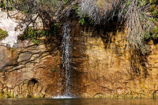 小さな水の流れがグレンキャニオンの中の砂岩の壁を流れ 晴れた日には強大なコロラド川と合流する — ストック写真
